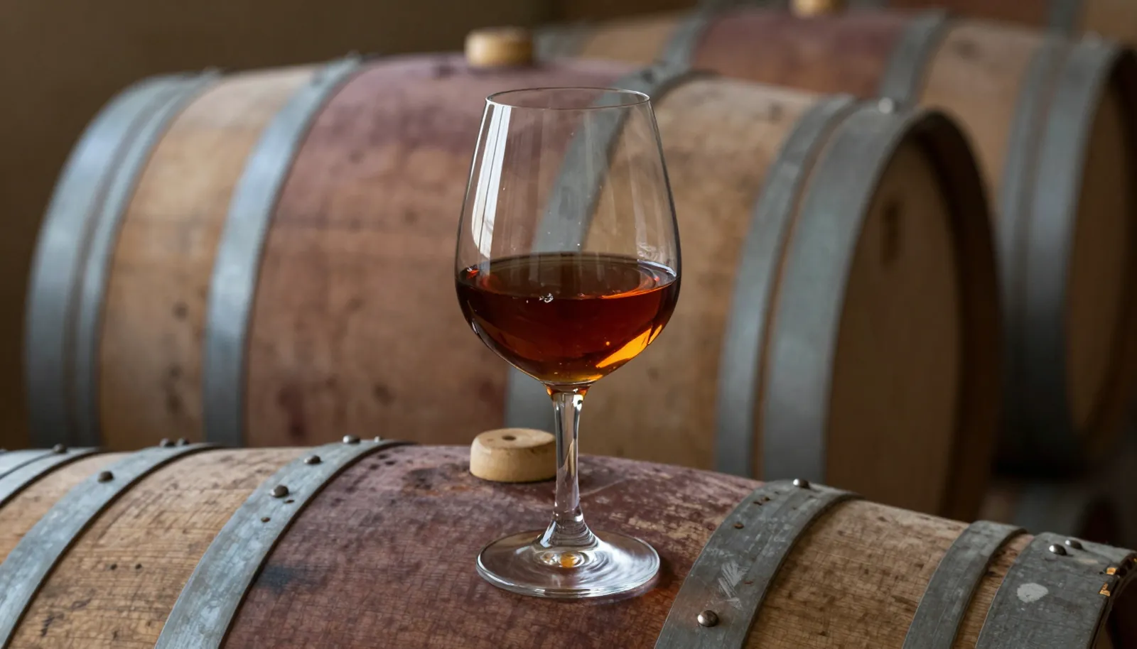 Ly armagnac màu hổ phách trên thùng gỗ sồi trong hầm