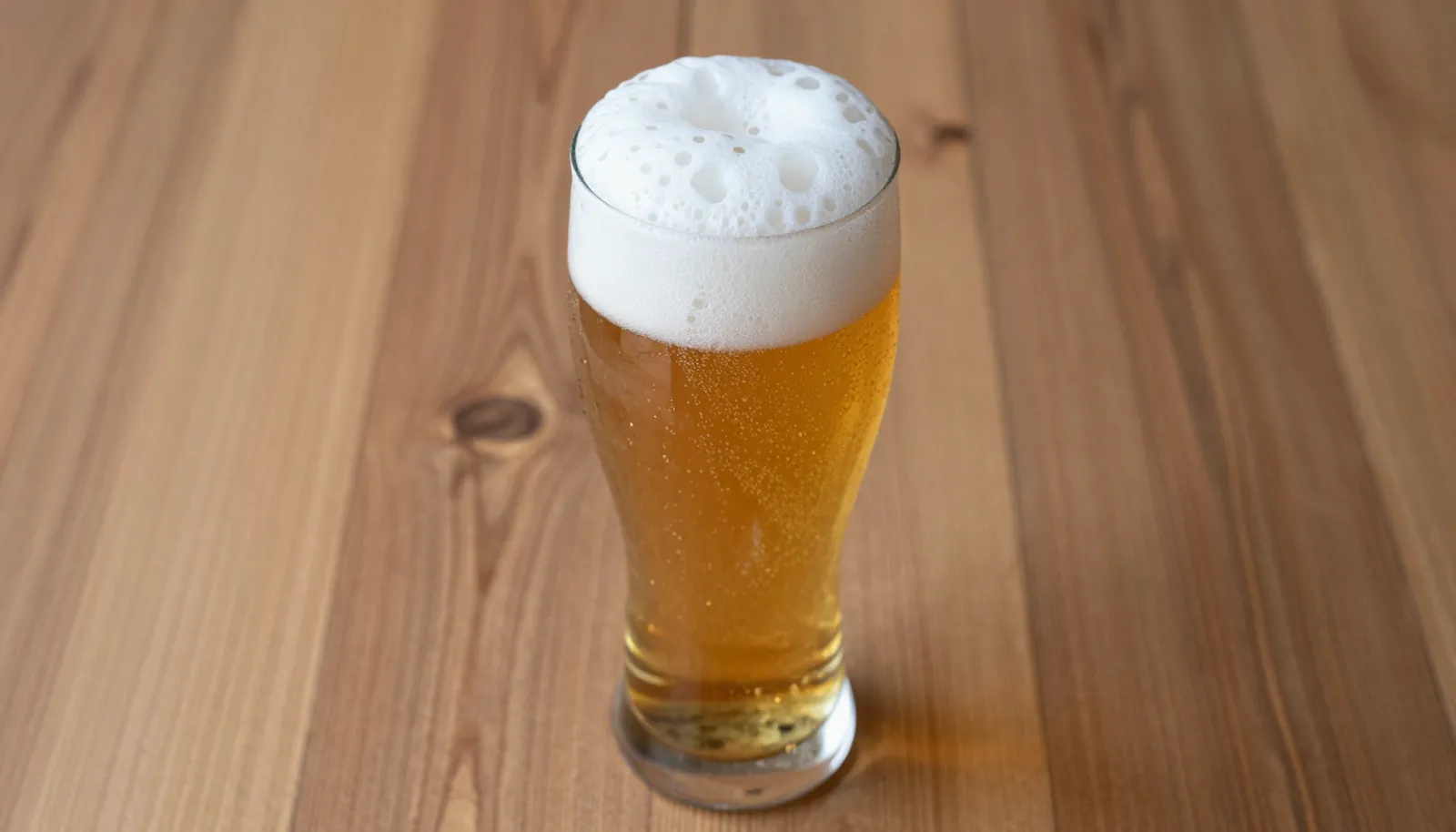 Ly bia Pilsner vàng óng với lớp bọt trắng dày