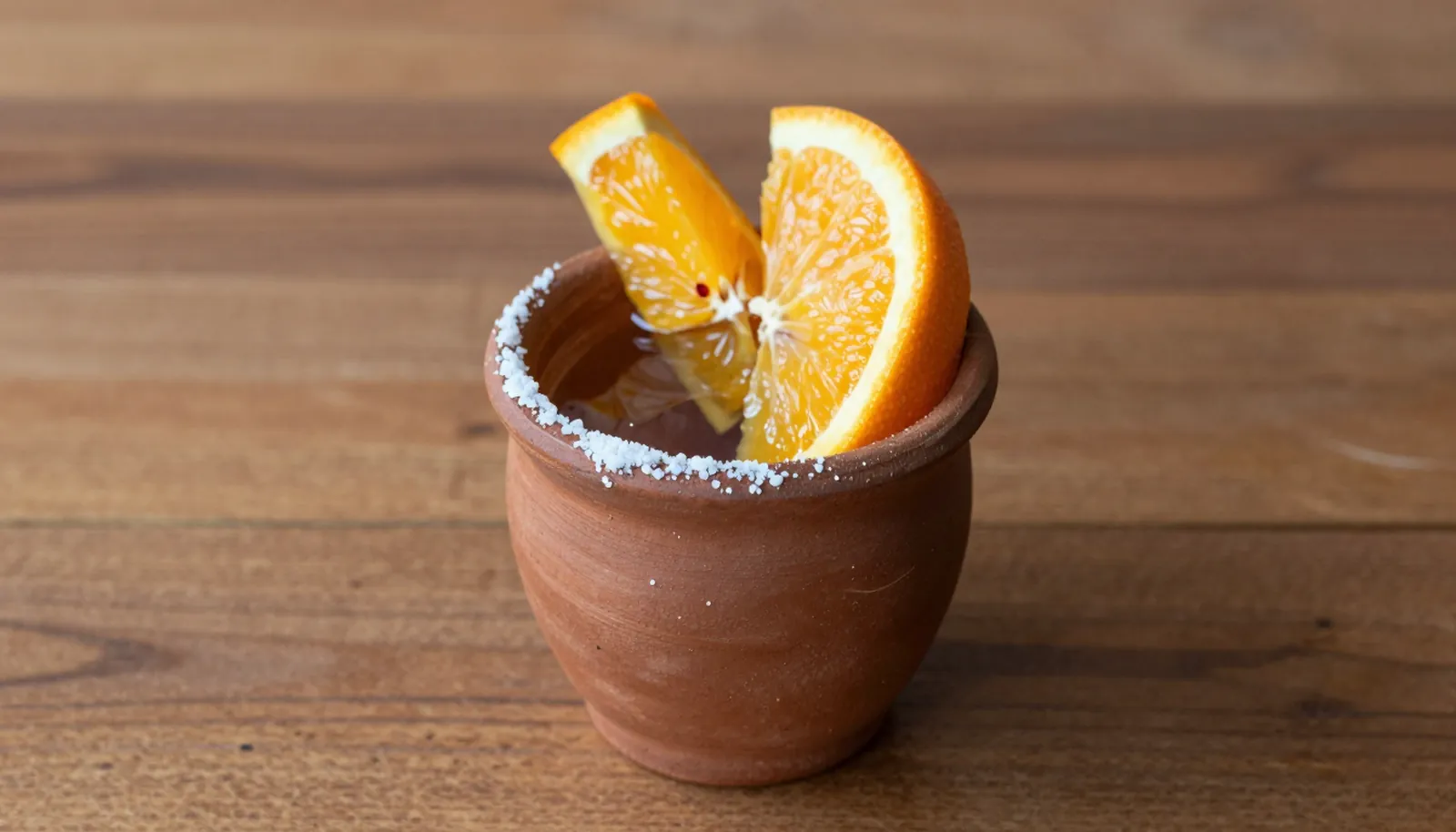Chén đất nung đựng mezcal với lát cam và muối ớt