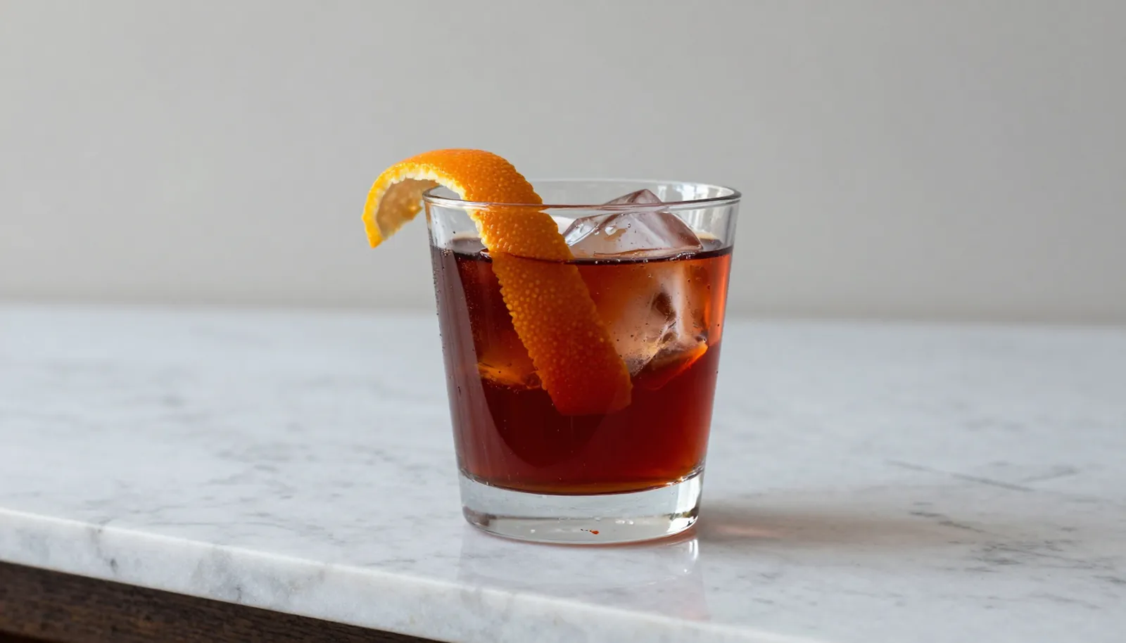Ly vermouth đỏ với đá và vỏ cam trên mặt đá cẩm thạch